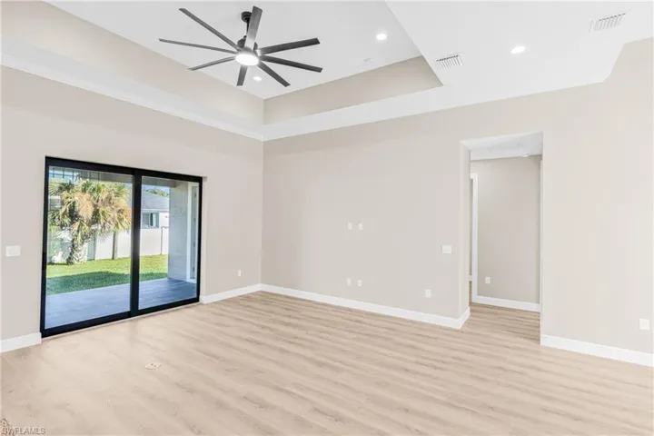 Living Room with light wood-type flooring, a raised ceiling, ceiling fan, recessed lighting, and crown molding