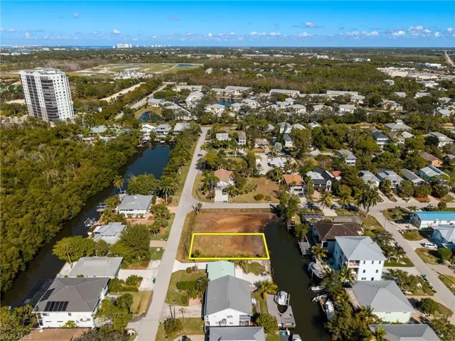 Aerial view of property's location featuring nearby suburban area, property boundaries highlighted, and a large body of water