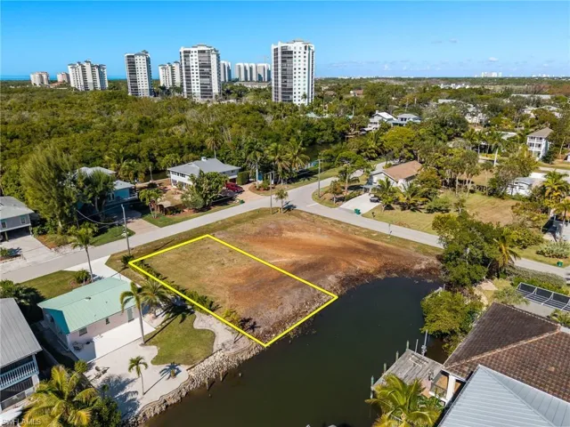 View of urban area with property boundaries highlighted and a nearby body of water