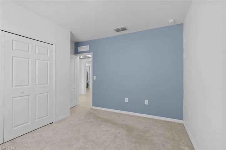 Unfurnished bedroom featuring carpet and a closet