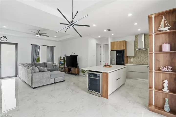 Kitchen featuring modern cabinets, open shelves, brown cabinetry, beverage cooler, and recessed lighting