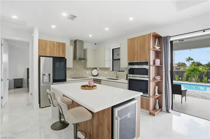 Kitchen with brown cabinetry, open shelves, a breakfast bar area, and modern cabinets