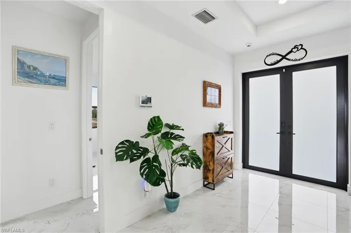 Foyer with light marble finish flooring and french doors