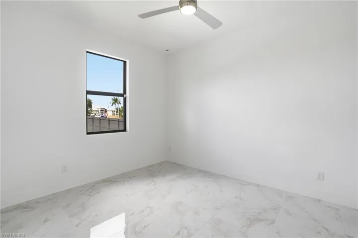 Spare room featuring baseboards and light marble finish flooring