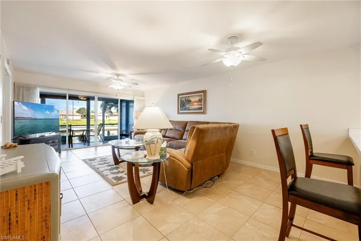Living room with light tile patterned flooring and ceiling fan