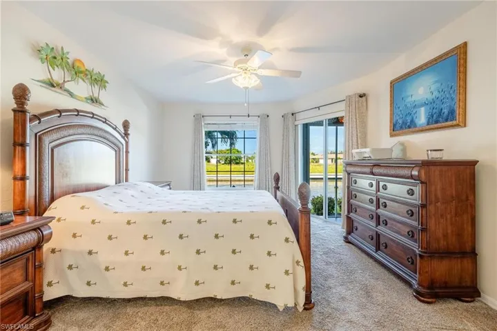 Primary bedroom featuring access to outside and ceiling fan