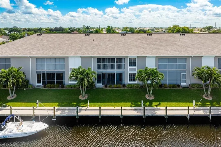 Rear view of property with a water view and a lawn