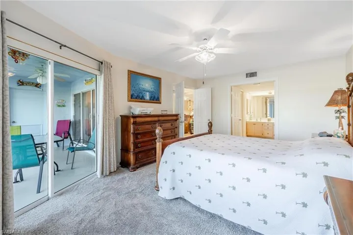 Primary bedroom featuring ceiling fan, connected bathroom, and access to outside