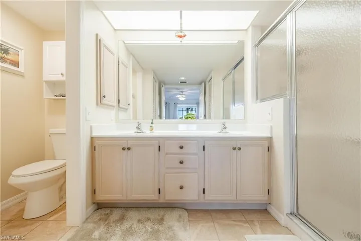 Bathroom featuring vanity, toilet, a shower with shower door
