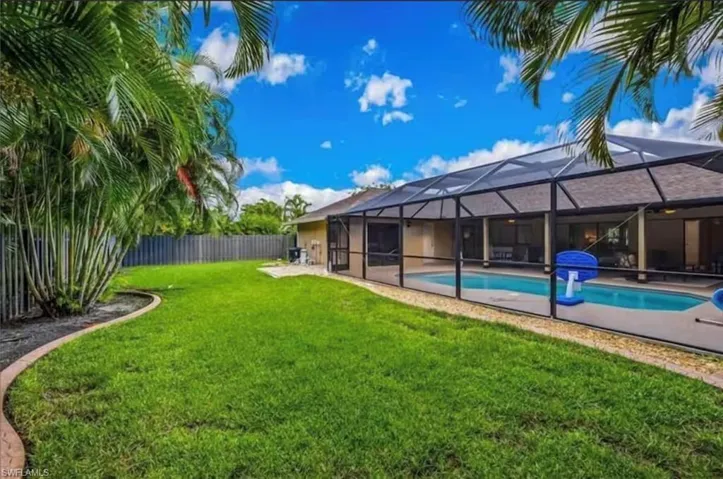View of yard featuring a lanai and a fenced in pool