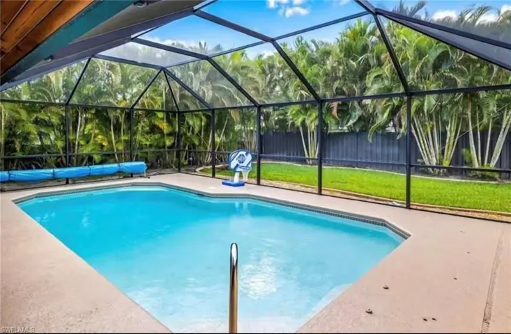 View of pool featuring a lawn, a lanai, and a patio