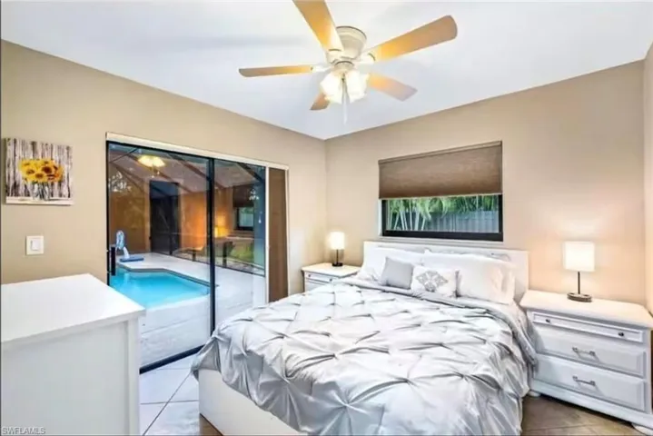 Tiled bedroom with access to exterior and ceiling fan