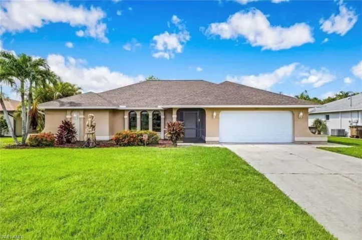 Ranch-style home with a garage, central air condition unit, and a front yard