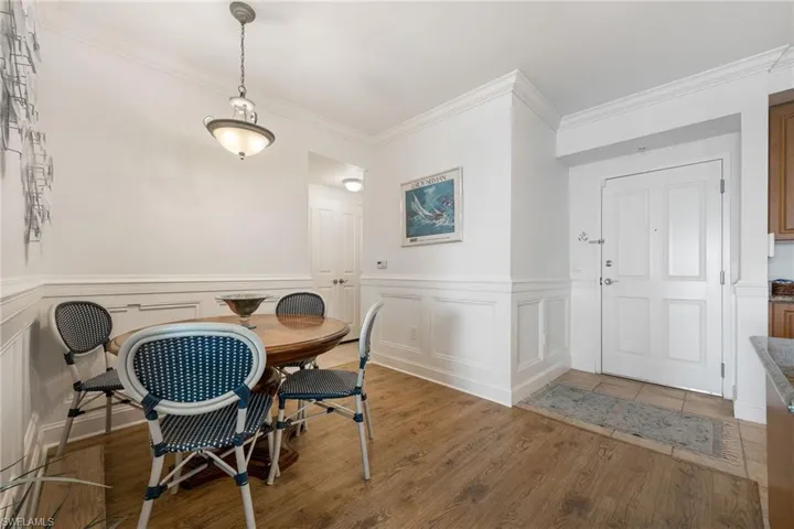 Dining space featuring wood-type flooring and ornamental molding