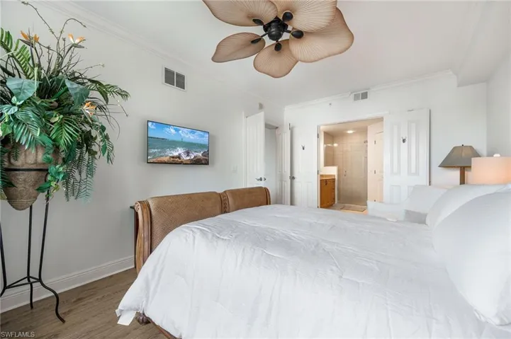 Bedroom featuring crown molding, ceiling fan, wood-type flooring, and connected bathroom