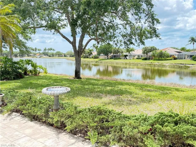 Serene long lake view with expansive green space, mature shade tree, and peaceful tropical setting.