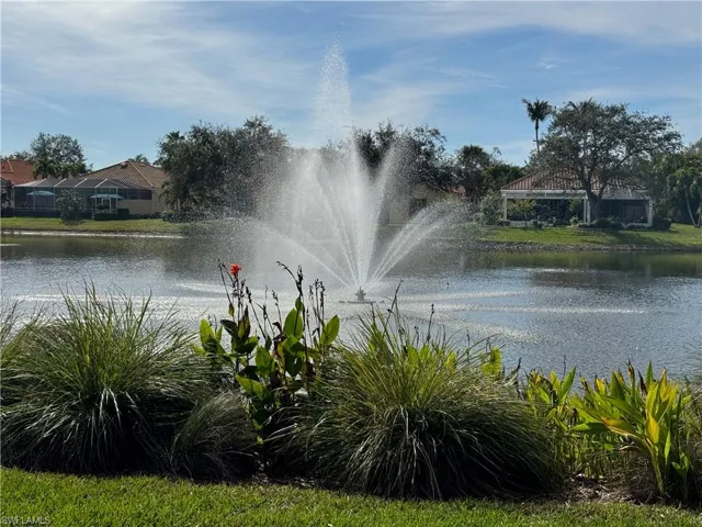 Scenic lake with fountain, lush tropical landscaping, and tranquil resort-style surroundings.