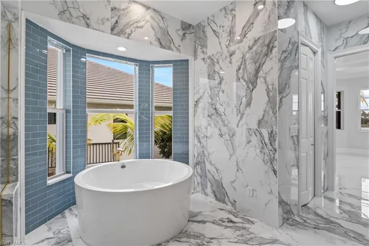Indulge in spa-like luxury with a circular soaking tub, dual vanities, and a walk-in shower. Every detail is designed for comfort and relaxation.