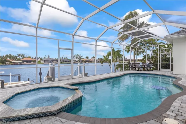 An outdoor oasis! The heated pool and spa overlook the tranquil canal, with a screened lanai, outdoor shower, and pool closet making entertaining a breeze.