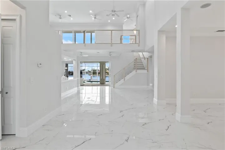 Soaring ceilings, wall-to-wall windows, and calming views of the canal make this the ultimate Florida living room.