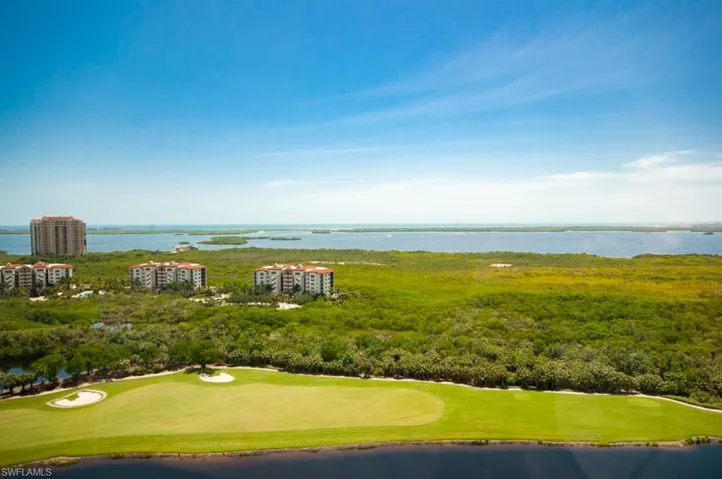 Drone / aerial view of a nearby body of water and a local golf course