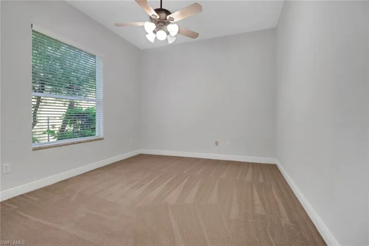 Guest bedroom featuring light colored carpeting, ceiling fan & large wall closet