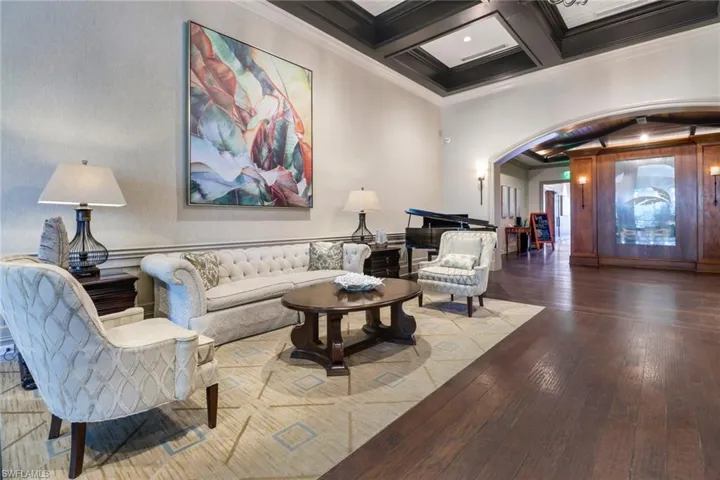 Clubhouse common room with coffered ceiling, ornamental molding & hardwood-style floors