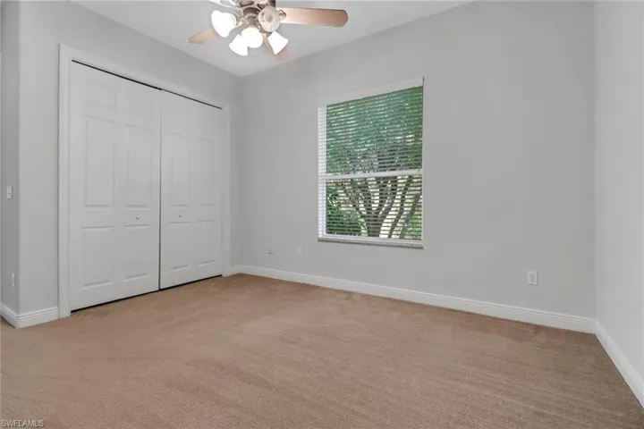 Unfurnished bedroom with ceiling fan, light colored carpet, and a closet
