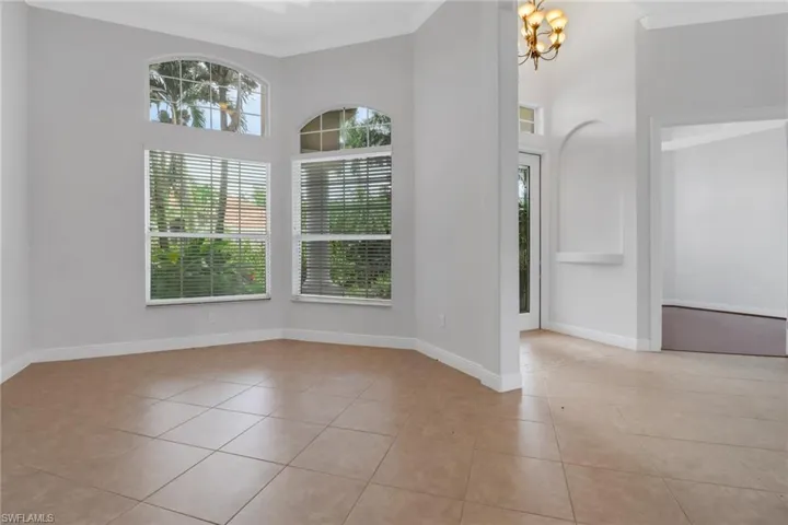 Tiled formal dining room featuring an inviting chandelier & crown molding