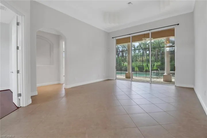Tiled formal living room with sliding glass doors to lanai & view of swimming pool overlooking golf course