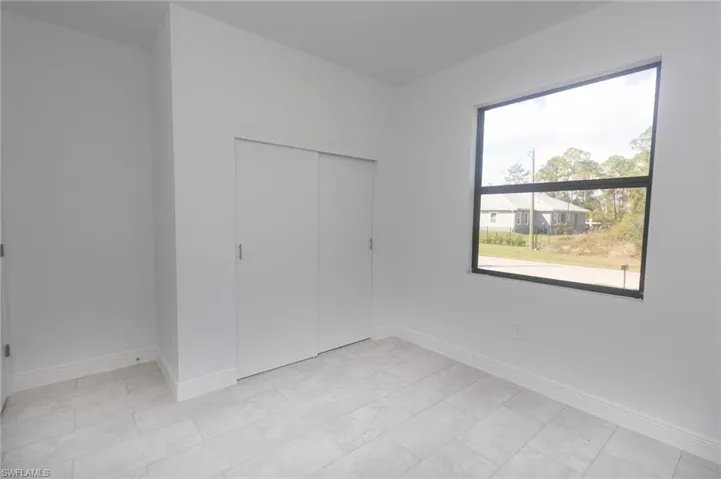 Bedroom featuring a closet and tile floors.