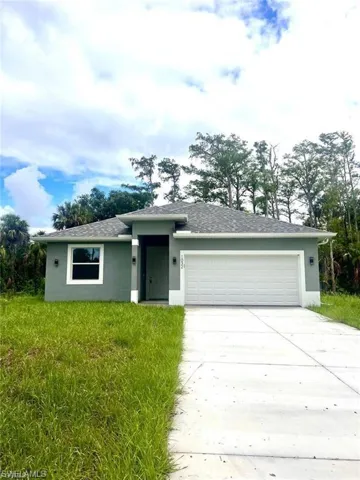 View of front of house featuring concrete driveway, a shingled roof, an attached garage, and stucco siding