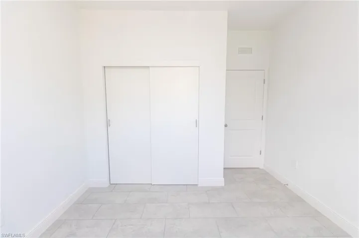 Bedroom featuring a closet and tile floors.