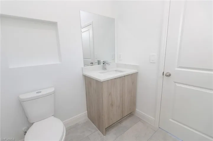 Full Jack and Jill bathroom featuring tile  floors, vanity, and a marble finish shower