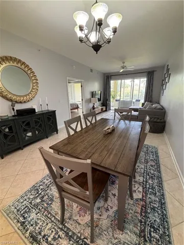 Dining area featuring a wood-finish dining table with seating for six, tile flooring, a chandelier, and console