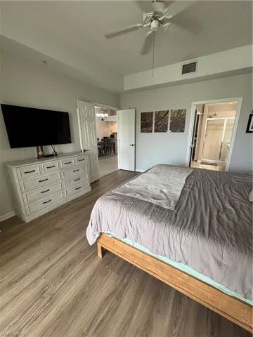 Spacious bedroom featuring wood-finish flooring, a ceiling fan, and high ceilings