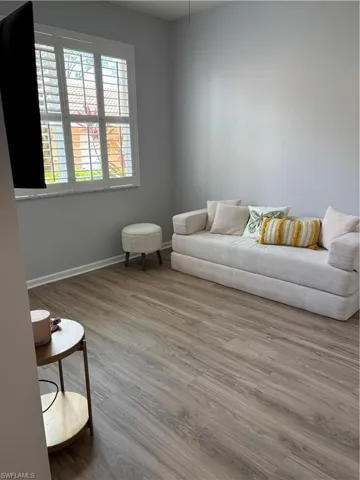 2nd bedroom has wood finish flooring and Boneless High Density Foam Queen sofa bed plus a mounted TV and plantation shutters