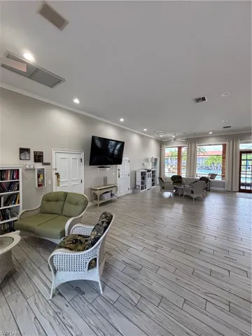 Clubhouse area with plenty of natural light, wood finished floors, crown molding, and recessed lighting