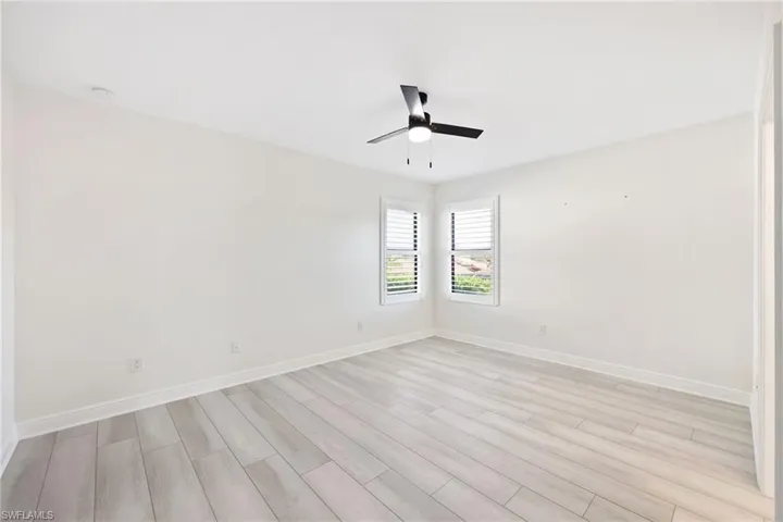 Primary Bedroom with light wood-type flooring and ceiling fan