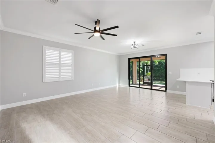 Living Room with ceiling fan, ornamental molding, and light hardwood / wood-style flooring