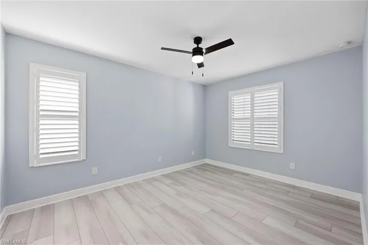 Empty room with ceiling fan and light wood-type flooring