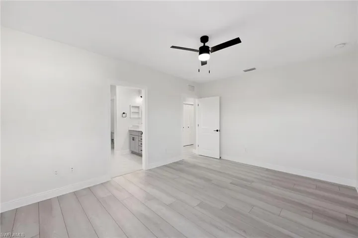 Primary Bedroom with light wood-type flooring and ceiling fan