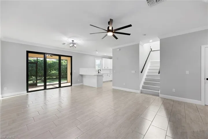 Living room with light hardwood / wood-style flooring, crown molding, and ceiling fan