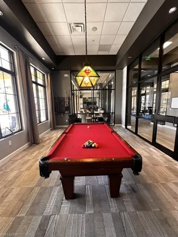 Exercise room featuring ceiling fan and a drop ceiling