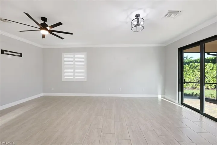Living Room with light hardwood / wood-style flooring, ornamental molding, and ceiling fan