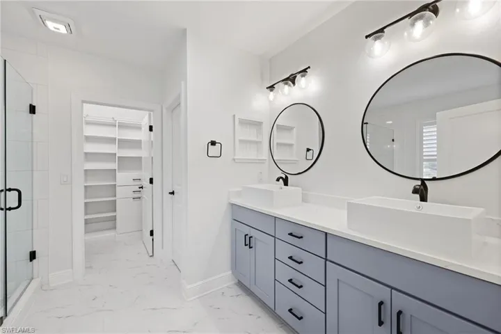 Bathroom featuring a shower with door and vanity