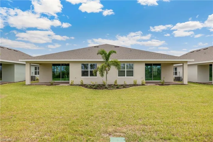 Rear view of property featuring a patio, a lawn, and cooling unit