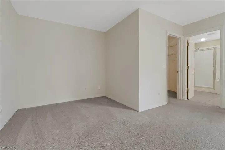Spare room featuring light carpet and baseboards