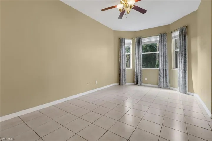 Empty room featuring light tile patterned floors and a ceiling fan