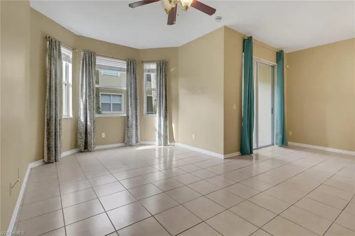 Empty room featuring ceiling fan and light tile patterned flooring